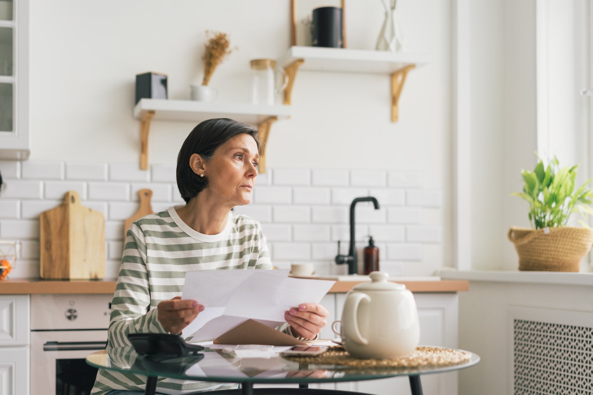 Woman reviewing paperwork at a table in her home