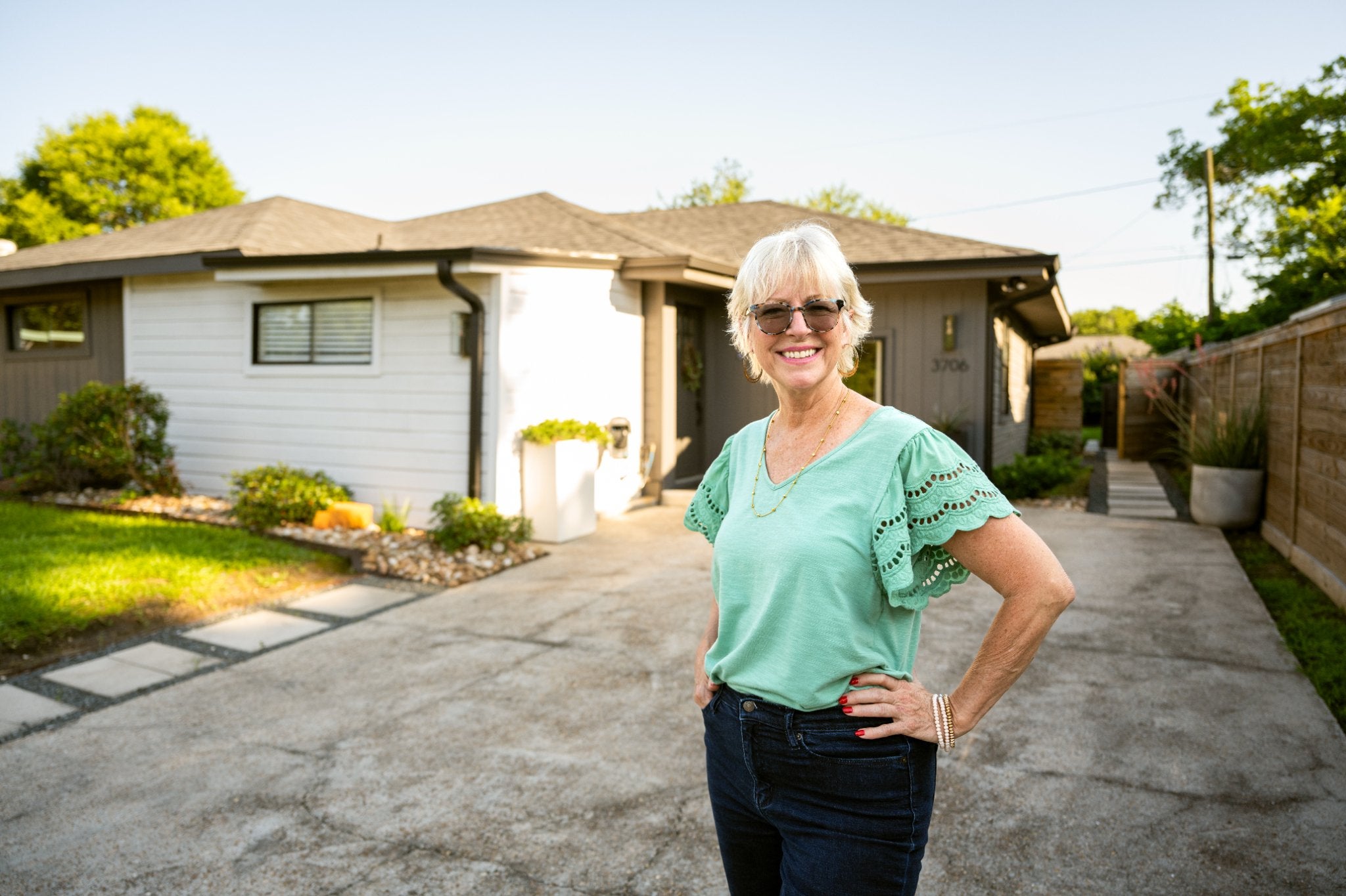 Homeowner standing outside her house, illustrating aging in place and independent living.