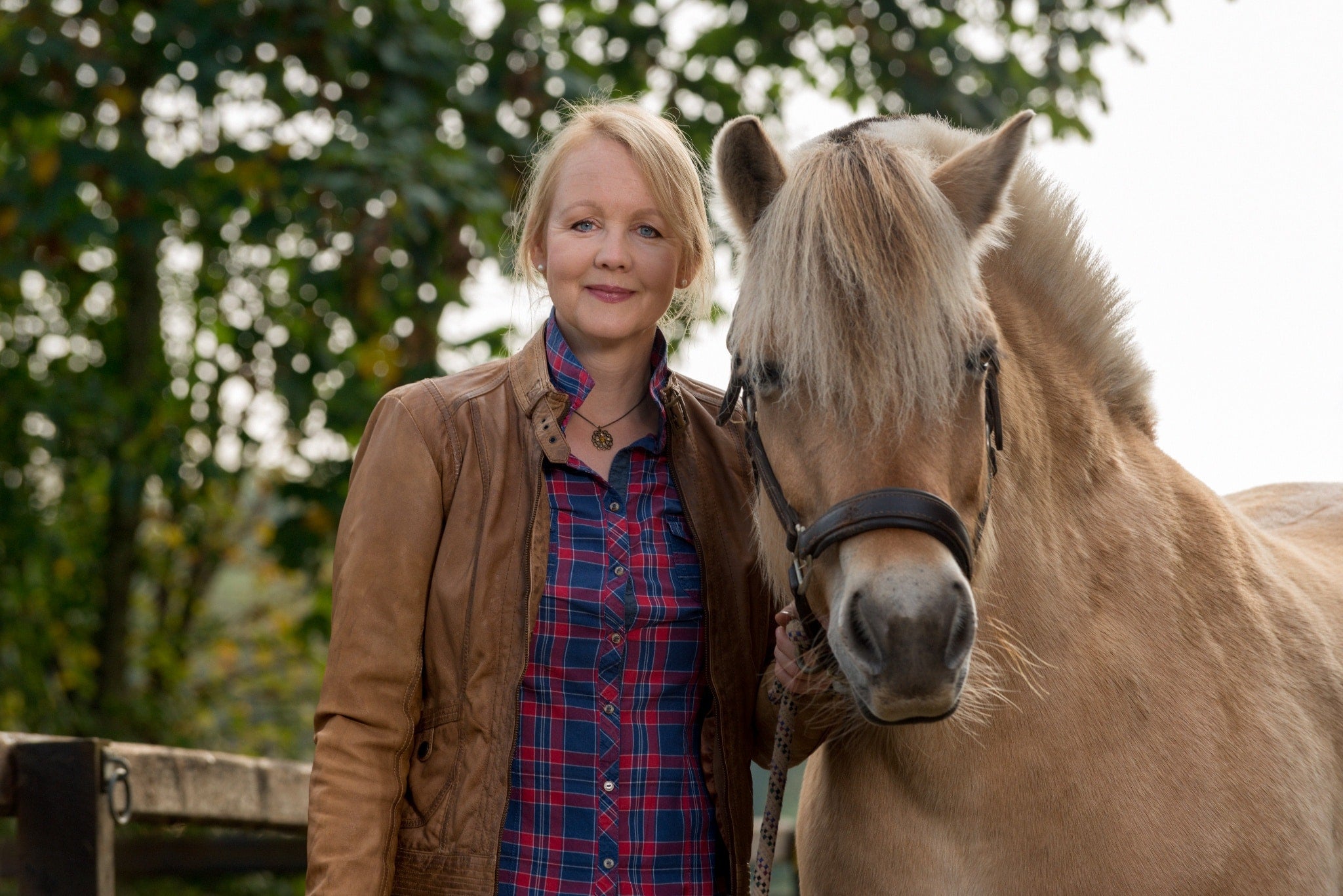 Woman standing beside a horse outdoors, reflecting a lifestyle supported by long-term homeownership